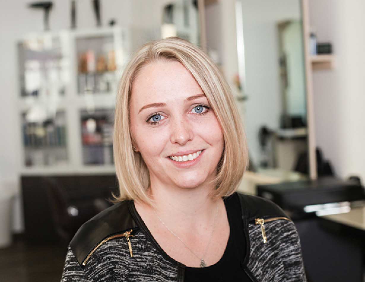 Lächelnde Stefanie Hinzer mit kinnlangem, blondem Haar in einem Friseursalon.